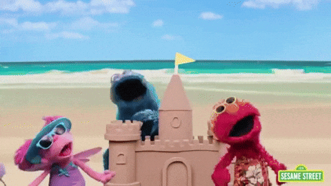 Sesame Street Characters Are Playing With A Sand Castle On The Beach GIF