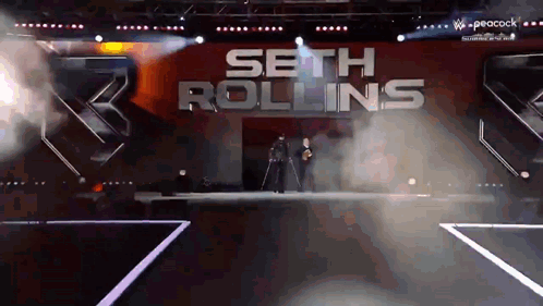 Seth Rollins Is Walking Down The Aisle Of A Stage GIF