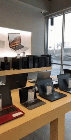 Several Laptops Are On Display In A Store Including One From Asus GIF