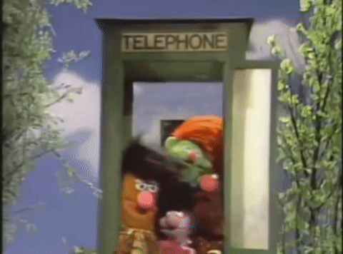 Several Sesame Street Characters Are In A Telephone Booth . GIF