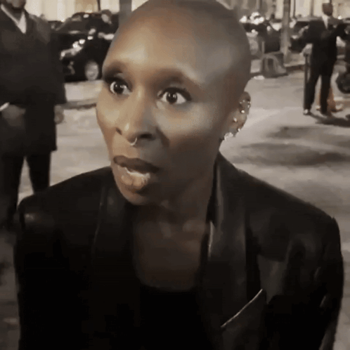 Shaved Head Woman in Earrings and Black Jacket