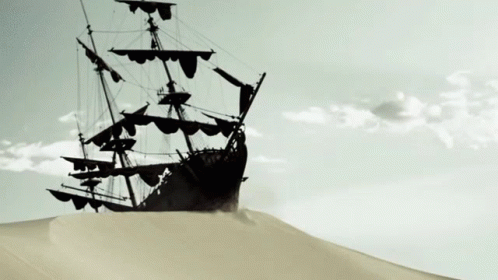 Ship Silhouetted Against Cloudy Sky on Sand Dune