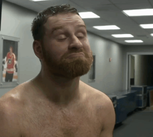 Shirtless Bearded Man in Hallway With Hockey Picture