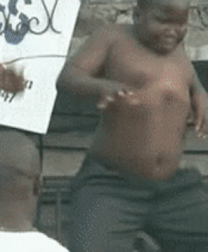 Shirtless Child Sitting Next To Man Holding Sign GIF