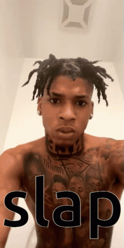 Shirtless Dreadlocked Man With Chest Tattoo and Slap