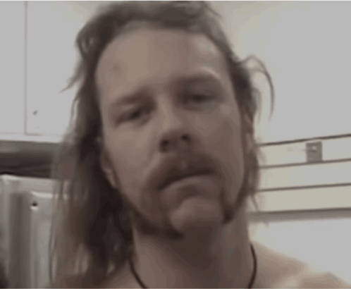 Shirtless Long-Haired Bearded Man Looking at Camera