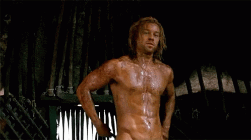 Shirtless Long-Haired Man Standing in Dark Room