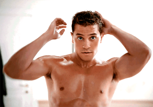 Shirtless Man Adjusting Hair in Mirror