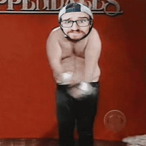 Shirtless Man Dancing In Front Of Pueblo Wall GIF