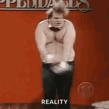 Shirtless Man Dancing on Stage With Reality Sign