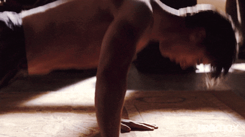 Shirtless Man Doing Push Ups on Wooden Floor