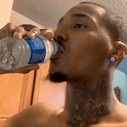 Shirtless Man Drinking Water From Bottle