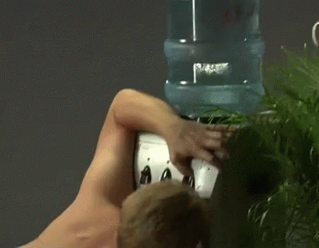 Shirtless Man Drinking Water From Water Dispenser