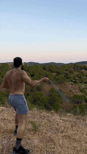 Shirtless Man Holding Hose in Field