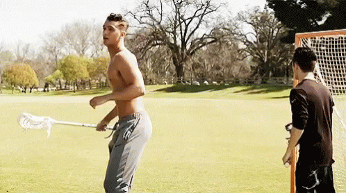 Shirtless Man Holding Lacrosse Stick With Another Man Behind