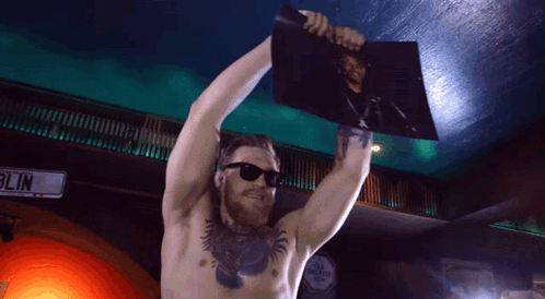 Shirtless Man Holding Picture in Front of Blin Sign