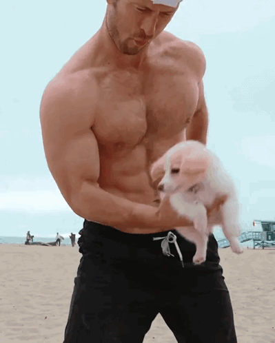 Shirtless Man Holding Small White Puppy GIF