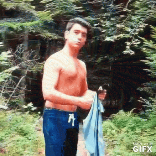 Shirtless Man Holding Towel in Woods