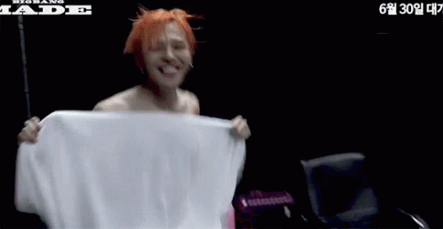 Shirtless Man Holding White Towel Next to Jade Chair