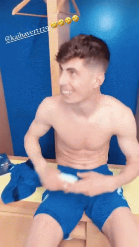 Shirtless Man In Blue Shorts Sitting On Dresser GIF
