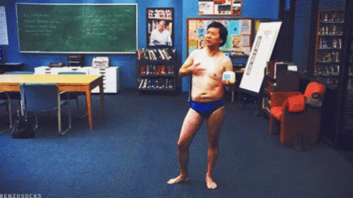 Shirtless Man in Blue Swim Trunks Dancing in Classroom Benzosocks