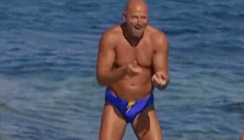 Shirtless Man in Blue Swim Trunks Jumping into Ocean