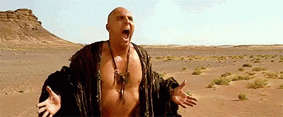 Shirtless Man in Desert With Mouth Open