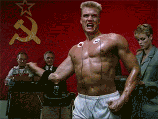 Shirtless Man in Front of Red Wall with Hammer and Sickle