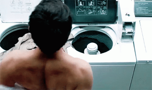 Shirtless Man In Front Of Washing Machine With Instructions GIF