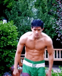 Shirtless Man in Green Shorts Standing in Garden