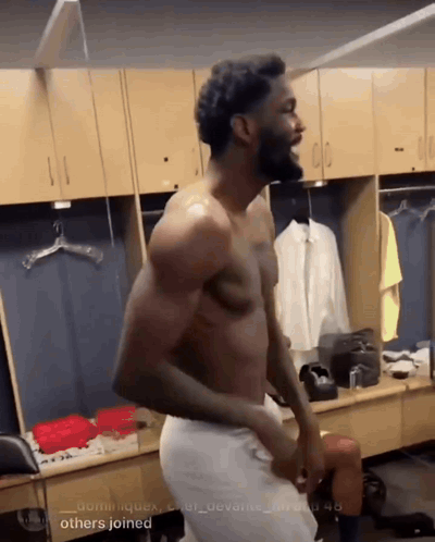 Shirtless Man in Locker Room with Others