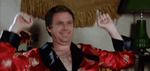 Shirtless Man in Red Robe Raising Arms