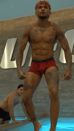 Shirtless Man In Red Underwear In Front Of Tommy Hilfiger Sign GIF