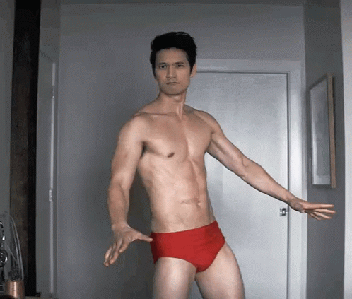 Shirtless Man in Red Underwear Standing by Door