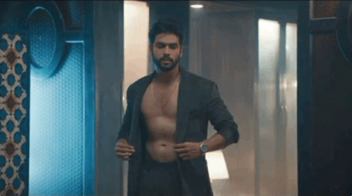 Shirtless Man in Suit in Dark Room