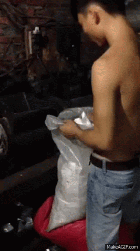 Shirtless Man Kneeling Holding Bag