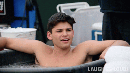Shirtless Man Laying In Tub Of Ice With Laugh And Loud GIF