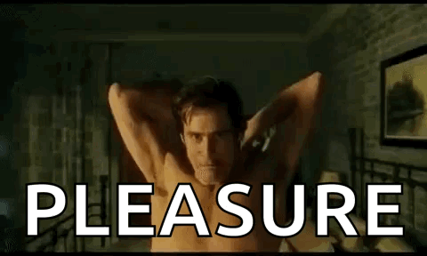 Shirtless Man Laying On Bed With Arms Outstretched Saying Pleasure GIF