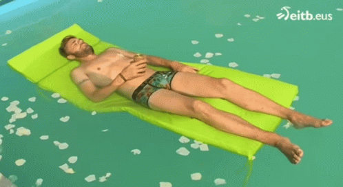 Shirtless Man Laying on Green Raft in Pool With eitb.eus