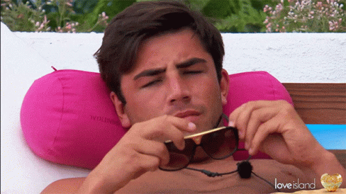 Shirtless Man Laying on Pink Pillow Love Island
