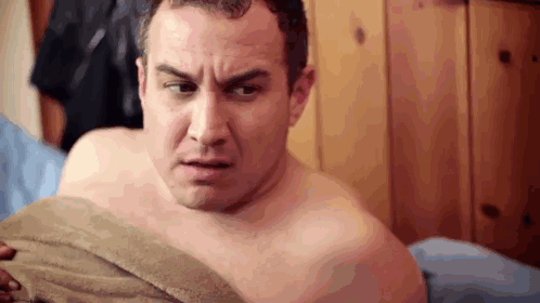 Shirtless Man Lying on Bed With Towel