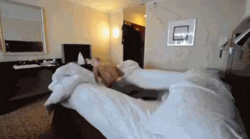 Shirtless Man Lying On Hotel Bed GIF