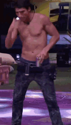 Shirtless Man on Stage Holding Can of Soda