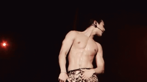 Shirtless Man on Stage With Microphone