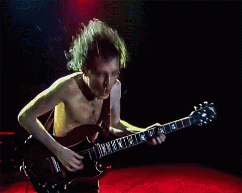 Shirtless Man Playing Guitar With 14 on Neck