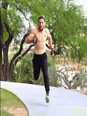 Shirtless Man Running on Path with Trees