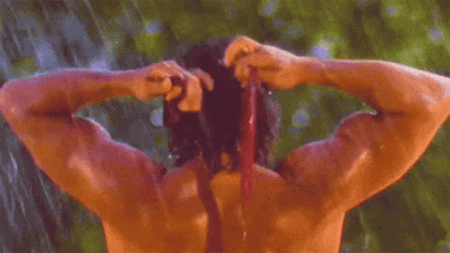 Shirtless Man Showering in Rain and Tying Hair