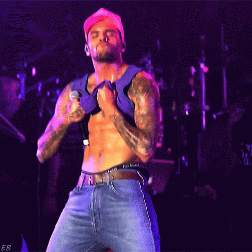 Shirtless Man Singing Into Microphone