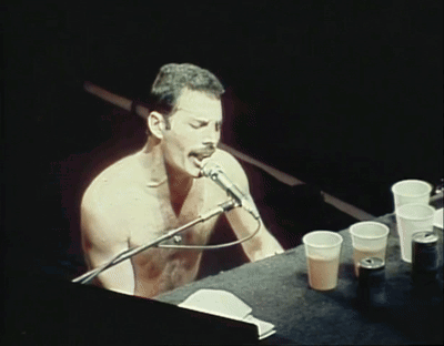 Shirtless Man Singing Into Microphone