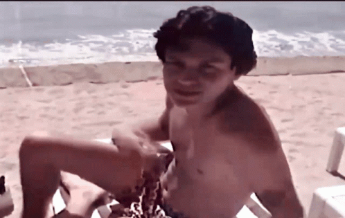 Shirtless Man Sitting on Beach Chair
